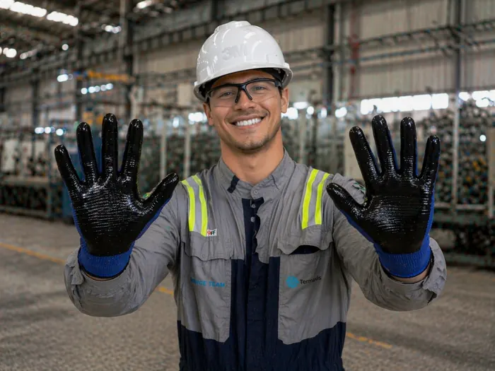 Técnico com capacete, óculos e luvas de proteção